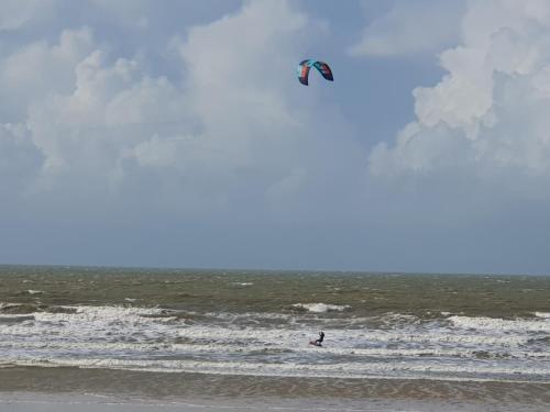 a person flying a kite in the ocean at Camping du Bois Dormant in Saint-Jean-de-Monts