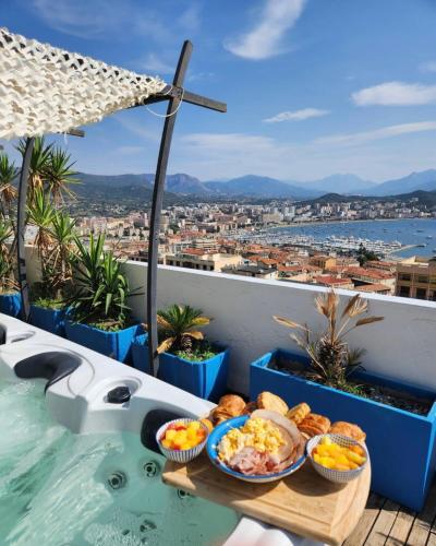 - un plateau de nourriture sur une table à côté de la piscine dans l'établissement Penthouse panoramique avec Jacuzzi, à Ajaccio