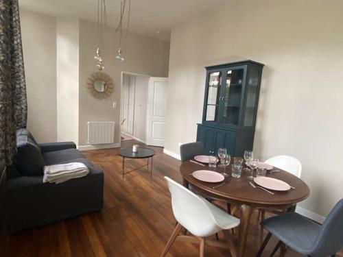a living room with a table and a couch at Le Philibert Roux Centre Ville d'Auxerre in Auxerre