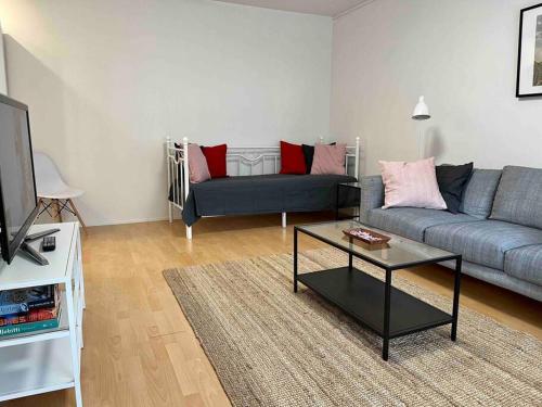 ein Wohnzimmer mit einem Sofa und einem Tisch in der Unterkunft Viihtyisä kaksio lähellä keskustaa ja yliopistoa. in Turku