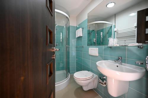 y baño con lavabo, aseo y espejo. en Casa EMA, en Bistriţa