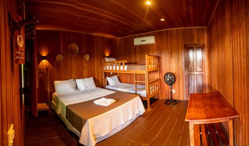 een slaapkamer met een bed en een stapelbed bij Manati Lodge in Manacapuru