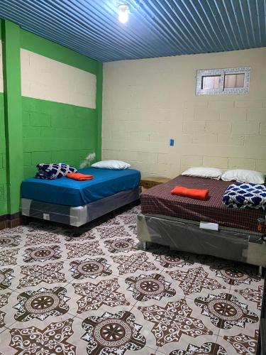two beds in a room with green walls at Casa Julián Cotuc in San Juan La Laguna