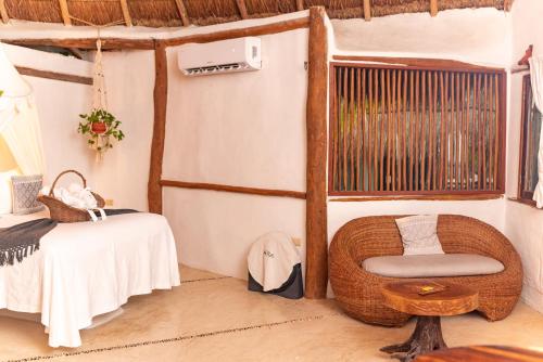 a room with a rattan chair and a table at Casa Takywara in Holbox Island