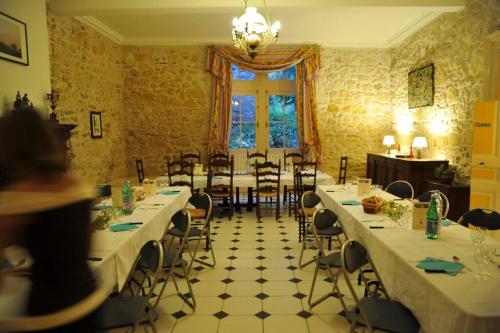 une salle à manger avec tables et chaises et une fenêtre dans l'établissement La Maison des Coteaux, à Ruffiac