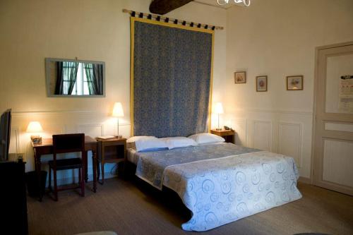 une chambre avec deux lits et un bureau et une fenêtre dans l'établissement La Maison des Coteaux, à Ruffiac