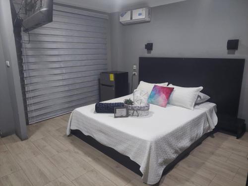 um quarto com uma cama grande com lençóis brancos e almofadas coloridas em W Hotel em Pasaje