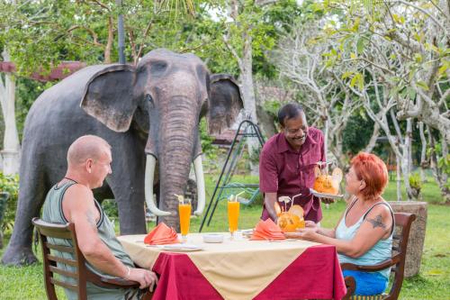 Eine Gruppe von Menschen, die an einem Tisch mit einem Elefanten sitzen in der Unterkunft AIDA Hotel - Bentota in Bentota