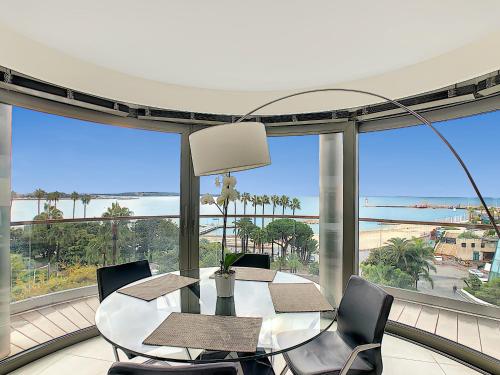 une salle à manger avec une table et des chaises et une grande fenêtre dans l'établissement 7 Croisette, à Cannes