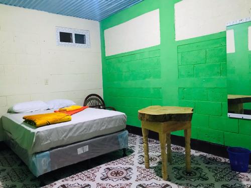 a green room with a bed and a table at Casa Julián Cotuc in San Juan La Laguna