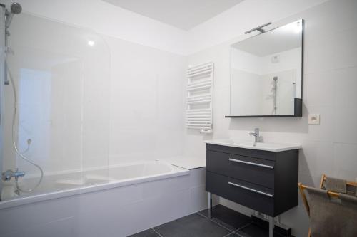 y baño con lavabo, bañera y espejo. en GuestReady - Elegant nature escape in vibrant Nice en Niza