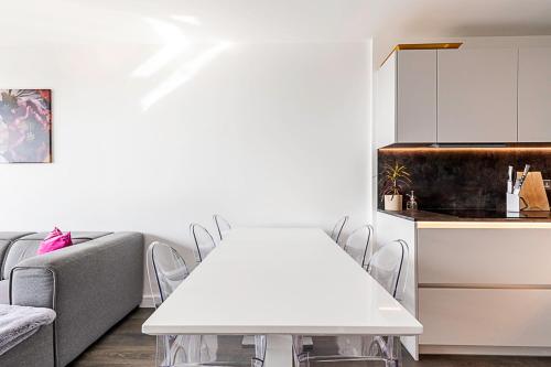 sala de estar con mesa blanca y sillas en Charming West London Nest, en Londres
