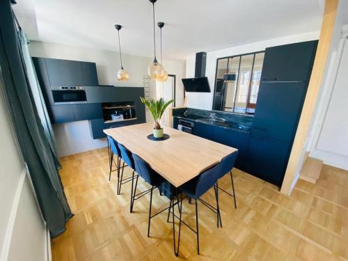 une cuisine avec une table en bois et des armoires bleues dans l'établissement Appartement 6 personnes hyper-centre de Tours, à Tours