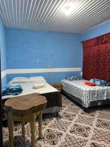 two beds in a room with blue walls at Casa Julián Cotuc in San Juan La Laguna