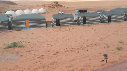 a group of domes in a desert with a dirt field at Sultan Luxury Camp in Wadi Rum