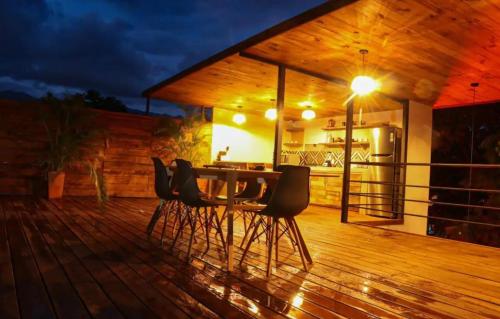 a wooden deck with a table and chairs at night at Casa Oaxaca in Oaxaca City