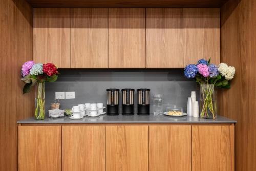 a room with two vases with flowers on a shelf at Hotel Holiday Inn Express & Suites Medellin by IHG in Medellín