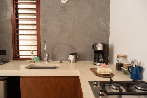 a kitchen counter with a sink and a stove at Casa Takywara in Holbox Island