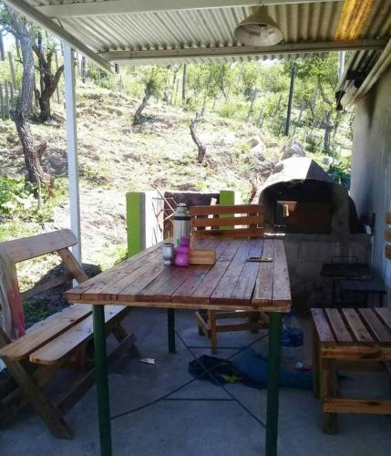 een houten picknicktafel voor een buitenoven bij Cabañas Mi genio amor in San Luis