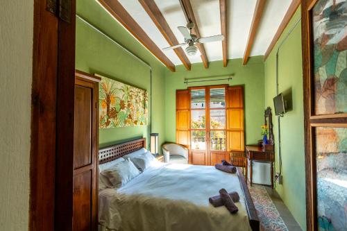 ein Schlafzimmer mit grünen Wänden und einem Bett mit Teddybären darauf in der Unterkunft Ibiza Boutique Guest House in Ibiza-Stadt