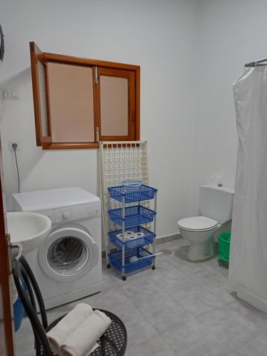 a bathroom with a washing machine and a toilet at Pension Alvarez in El Tablero