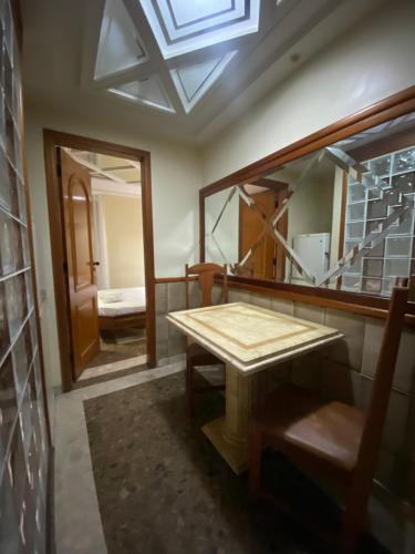 Cette chambre comprend une table en bois et un miroir. dans l'établissement Megara, à Rio de Janeiro