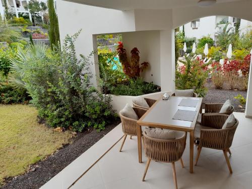 a patio with a table and chairs and a garden at Palmmar Jardines NEW 2bedroom ISORA 0,4 Appt 105m2 with garden in Palm-mar