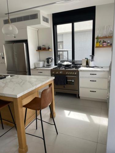 a kitchen with a table and a stove in it at Aloni House In Dagan in Even Yehuda