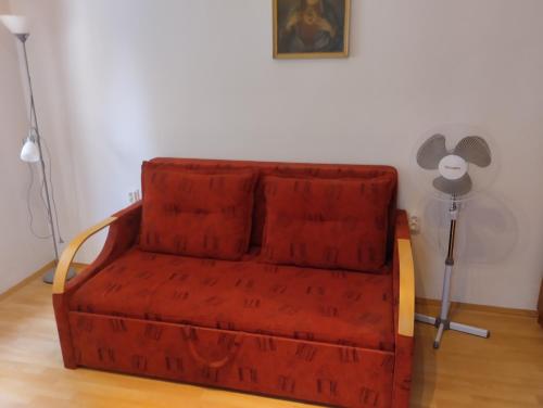 a red couch in the corner of a room at Aliz és Martin vendégház in Balatonmáriafürdő