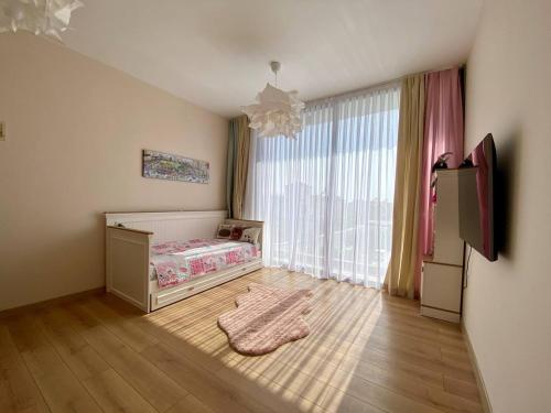 een slaapkamer met een bed en een groot raam bij Emerald villa Yenibogazici in Yenibosazici