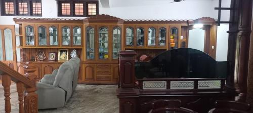 a living room with a large wooden cabinet at Green Heaven Kumarakom in Kumarakom