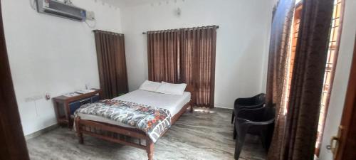 a bedroom with a bed and a chair in it at Green Heaven Kumarakom in Kumarakom