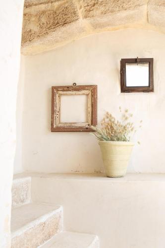 a picture frame on a wall with a plant in a vase at Dimore Santagaeta in Racale