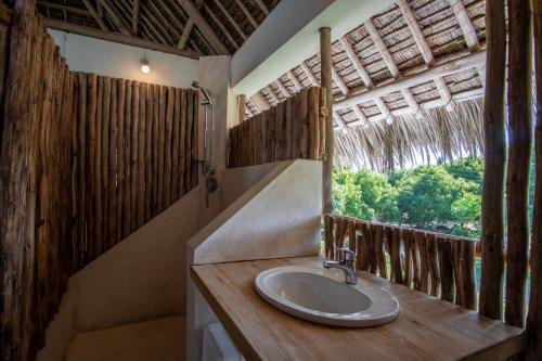 a bathroom with a sink and a window at Rafiki Village in Watamu