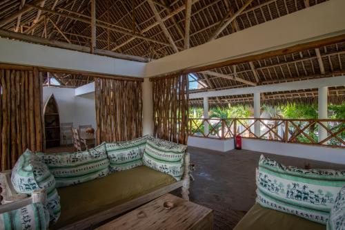 a living room with a couch and some windows at Rafiki Village in Watamu