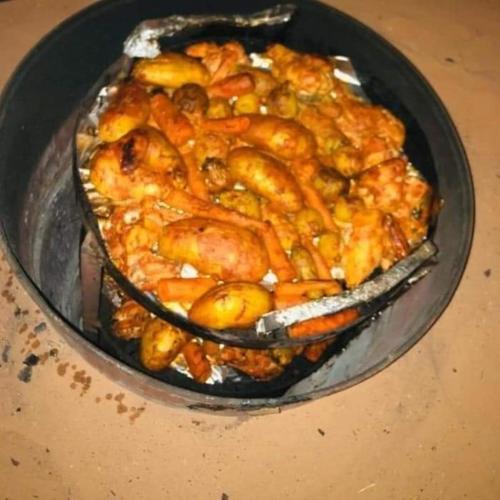 a bowl of food with chicken and vegetables in it at Sultan Luxury Camp in Wadi Rum