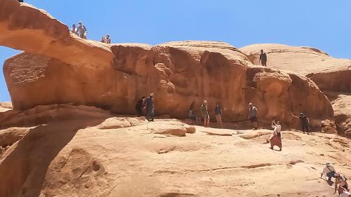 a group of people standing on a rock formation at Sultan Luxury Camp in Wadi Rum