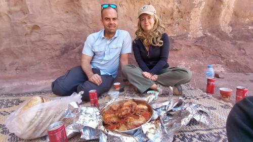 a man and woman sitting next to a table with food at Sultan Luxury Camp in Wadi Rum