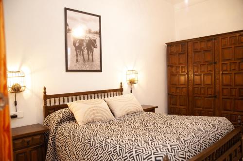 1 dormitorio con 1 cama y una foto en la pared en Vivienda Rural Casa Tavara, en El Ojuelo
