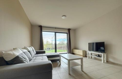a living room with a couch and a tv at Station 64 B1 Charleroi-Airport in Charleroi