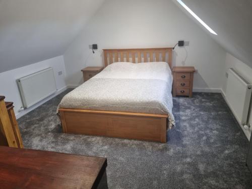 1 dormitorio con 1 cama y 2 mesitas de noche en Ole Butt Cottage, en Cinderford