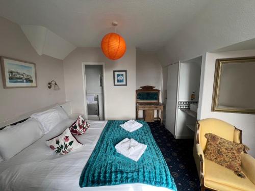 a bedroom with a large bed with a green blanket at Penzance Seaside studios in Penzance