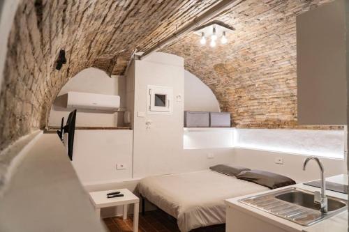 um quarto com uma cama e uma parede de tijolos em Appartamento in centro a Brescia:La Piccola House em Brescia