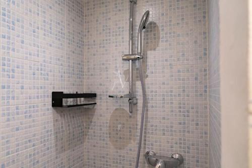um chuveiro numa casa de banho com azulejos azuis em Appartamento in centro a Brescia:La Piccola House em Brescia