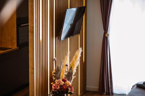 a room with a mirror and a vase of flowers at Alpine Line Studio with pool & spa in Sinaia