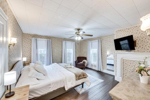 a bedroom with a large bed and a fireplace at Charming Dutch Country River Haven Home with Deck 