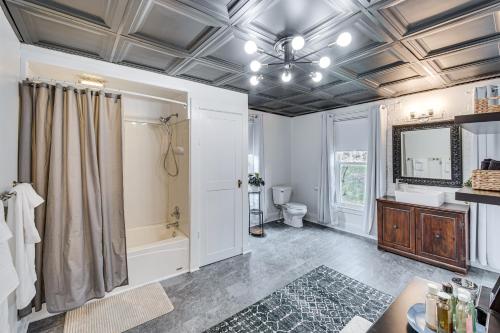 a bathroom with a tub and a toilet and a shower at Charming Dutch Country River Haven Home with Deck 