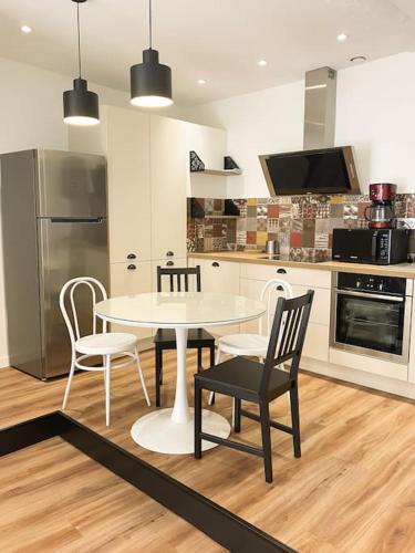 une cuisine avec une table et des chaises dans une cuisine dans l'établissement NOUVEAU Maison Bourg Cournon 5 pers 2 chambres, à Le Cendre