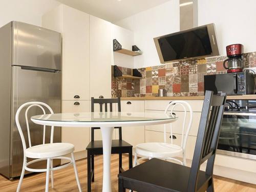 eine Küche mit einem Tisch, 2 Stühlen und einem Kühlschrank in der Unterkunft NOUVEAU Maison Bourg Cournon 5 pers 2 chambres in Le Cendre