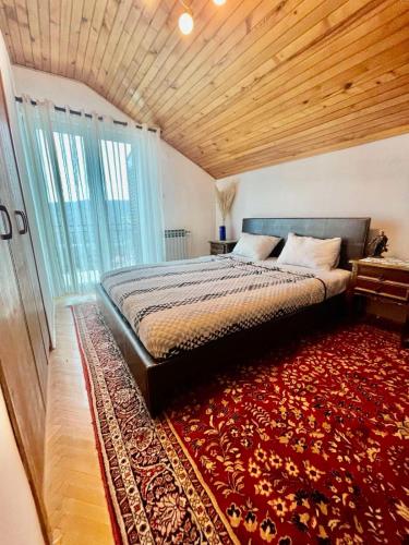 a bedroom with a large bed and a red rug at VILA MARTINA in Herceg-Novi